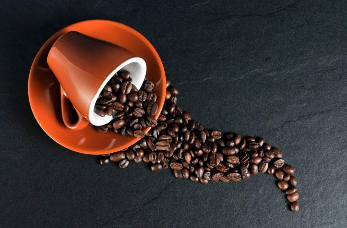 Imagine cu o ceasca de cafea boabe rasturnata