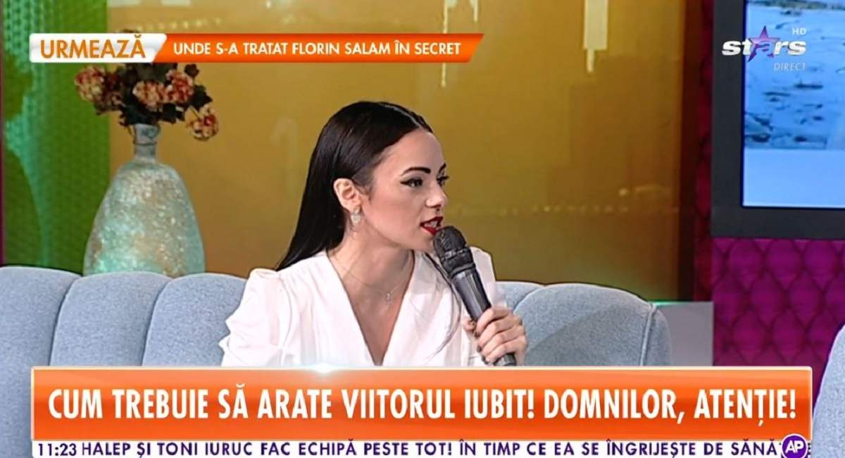 Cosmina Adam poartă o rochie albă și stă pe canapeaua bleu de la „Star Matinal”. Vedeta vorbește la microfon.