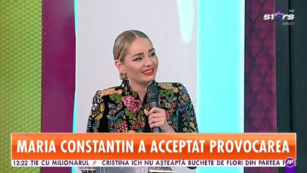 Mario Constantin se află în platoul „Star Matinal”. Vedeta poartă o bluză tradițională neagră cu elemente florale colorate și vorbește la microfon.