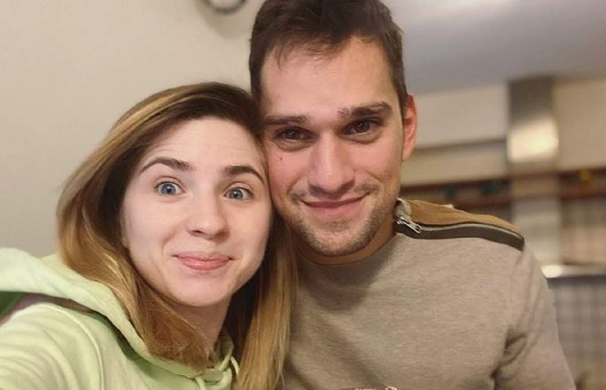 Cristina Ciobănașu și Vlad Gherman într-un selfie. Ea poartă un hanorac verde și el o bluză maro. Amândoi zâmbesc.