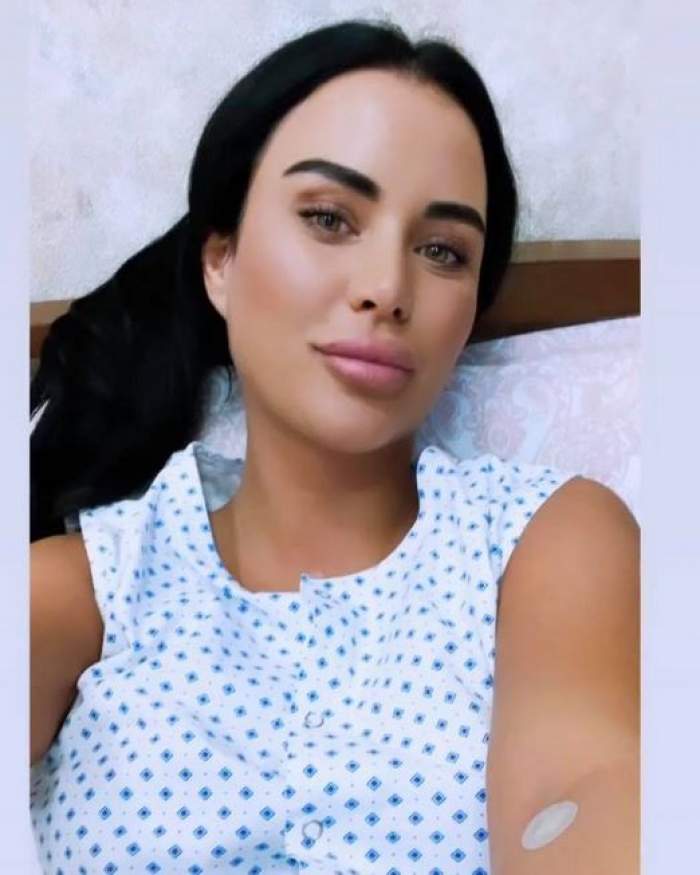 Daniela Crudu își face un selfie pe patul de spital, după ce și-a schimbat silicoanele. Vedeta poartă o pijama albă cu niște carouri bleu.