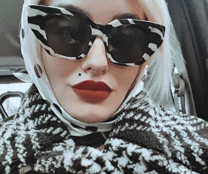 Ana Morodan este în mașină. Vedeta poartă o pereche de ochelari de soare și o haină de iarnă în alb și negru.