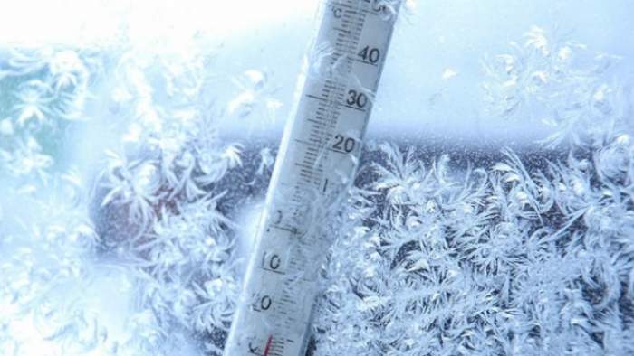 Un termometru înghețat  printre fulgi de zăpadă