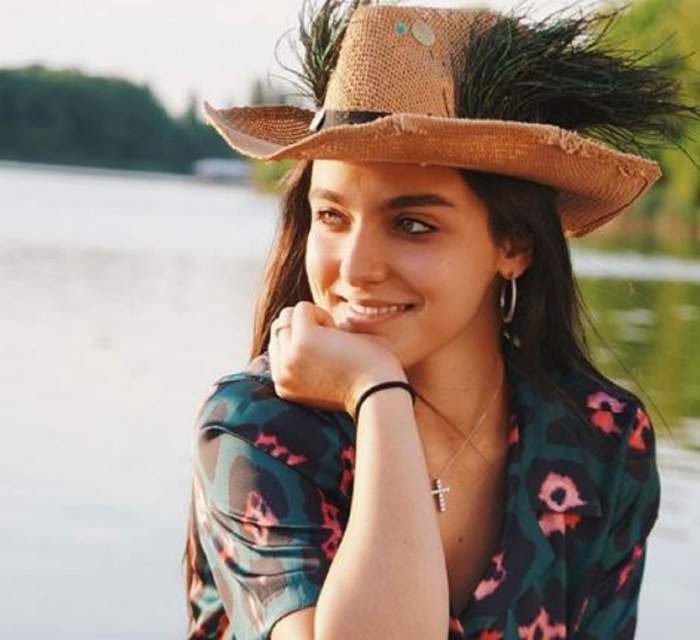 Alexia Eram, lângă lac, în ținută colorată, cu pălărie de paie pa cap