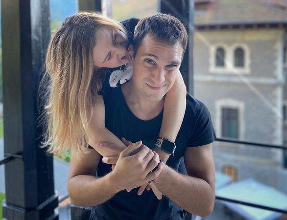 Cristina Ciobănașu îl îmbrățișează pe Vlad Gherman de la spate. Ambii poartă tricouri negre, iar artista îl mușcă de ureche pe actor.