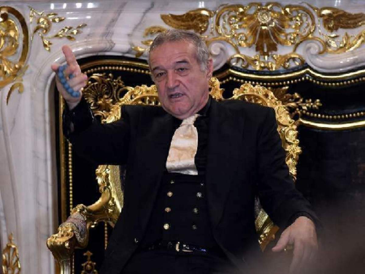 Gigi Becali stă pe un scaun auriu. Milionarul poartă un costum negru cu cravată aurie.