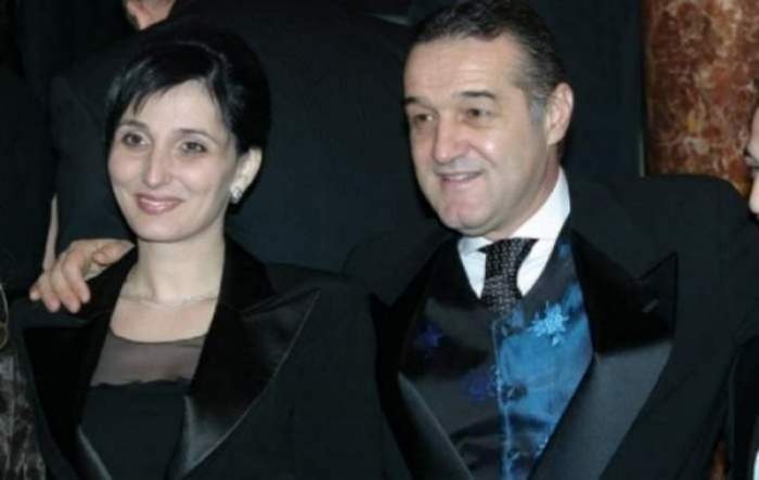Gigi Becali și soția lui când erau la un eveniment. El poartă un costum negru cu cămașă albă și vestă albastră, iar ea o rochie neagră.