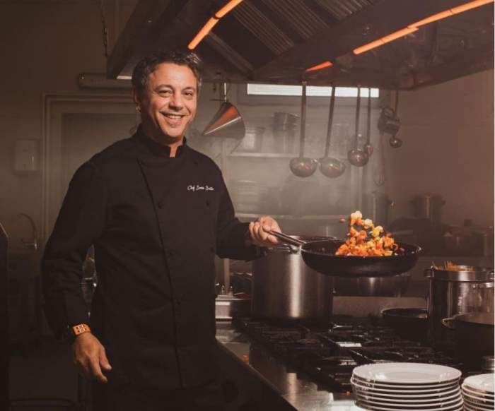 Chef Sorin Bontea gateste intr-o bucatarie profesionala si are echipament negru