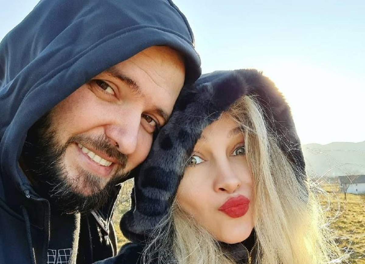Lora și Ionuț Ghenu își fac un selfie. Cei doi sunt afară. Ea poartă o haină de blană gri cu animal print negru, iar el o bluză de trening bleumarin.