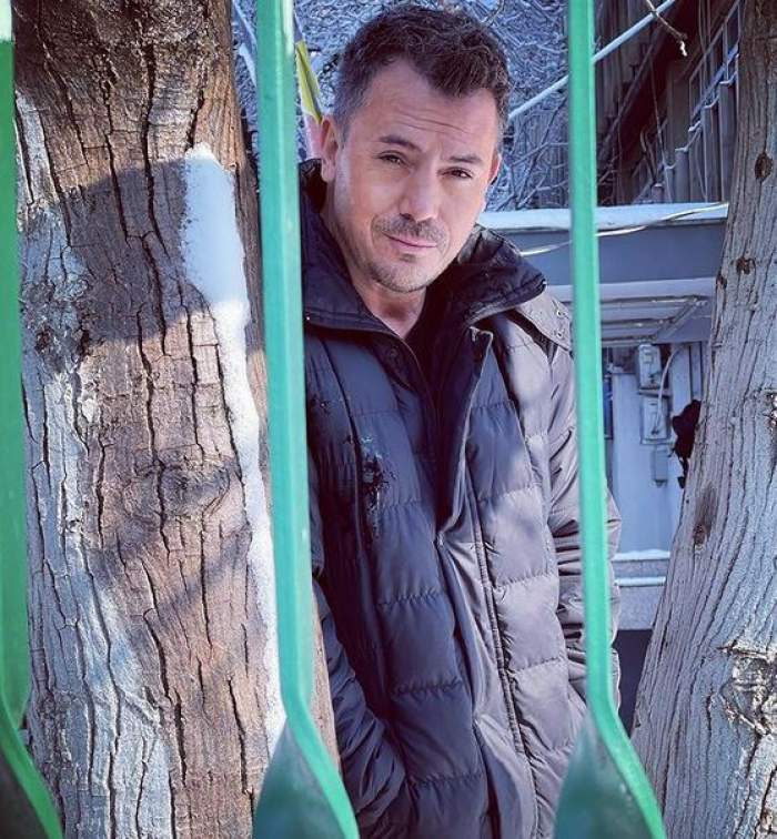 Răzvan Fodor e în parc. Artistul poartă o geacă neagră și se află printre niște copaci.