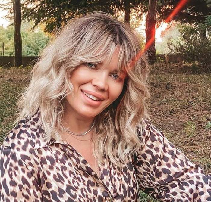 Gina Pistol e îmbrăcată într-o cămașă cu animal print, stil leopard. Vedeta zâmbește larg.