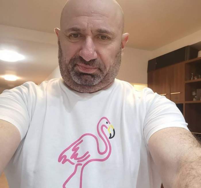 Cătălin Scărlătescu își face un selfie. Chef-ul poartă un tricou alb cu desen cu flamino roz în centru.