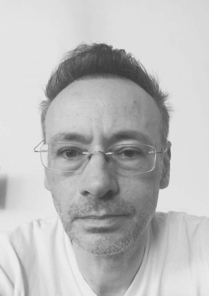 Mihai Albu într-un selfie. Designer-ul poartă un tricou alb și ochelari de vedere.