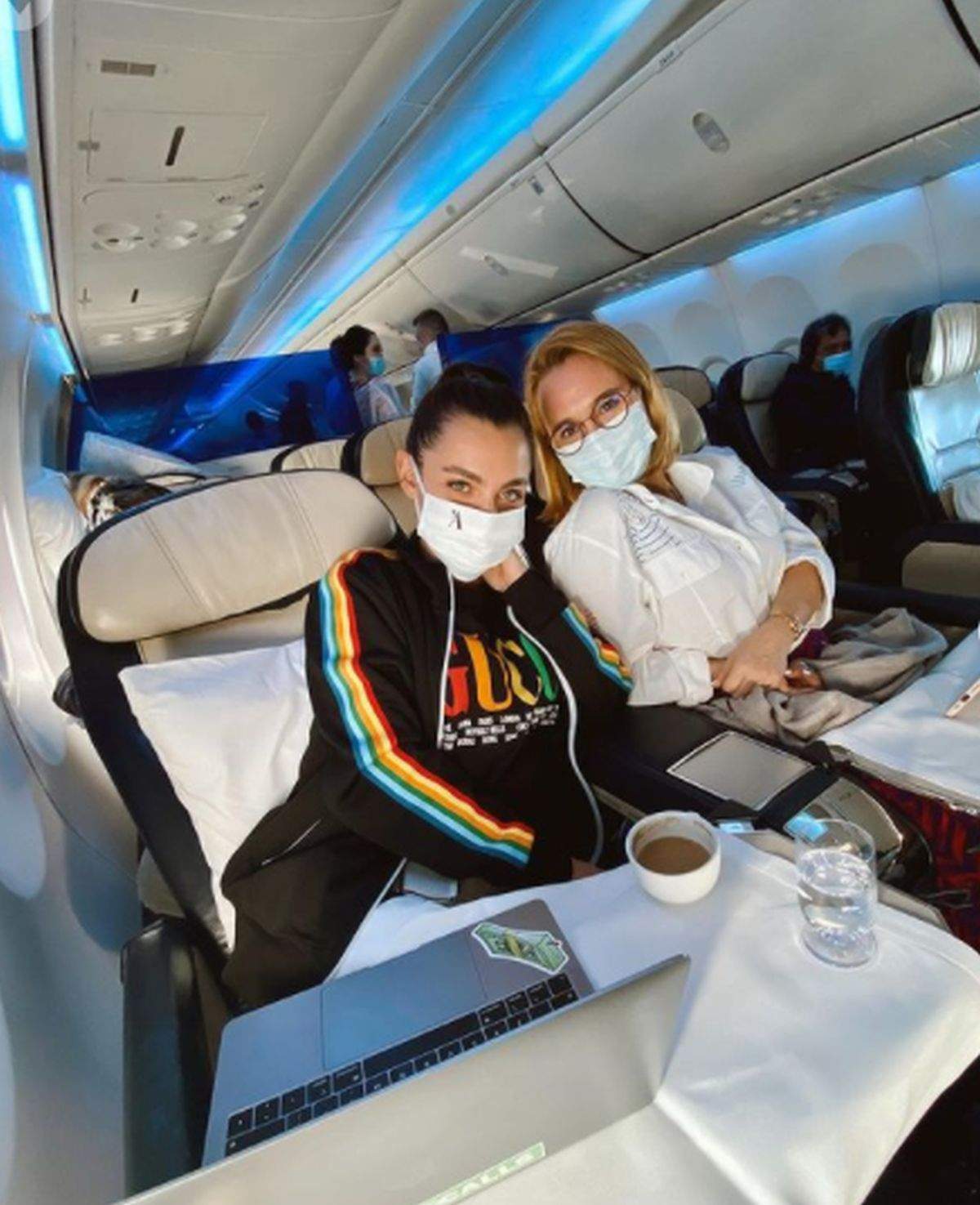 Alexia Eram și Andreea Esca cu masti pe fata in avion