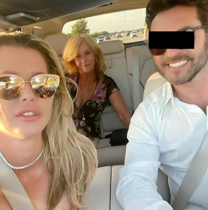 Alina Vidican face un selfie în mașină. Vedeta poartă ochelari de soare. În dreapta ei e un bărbat, iar pe bancheta din spate mama ei.