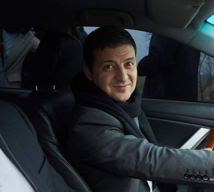 Președintele Ucrainei se află mașină. Acesta poartă un costum gri.