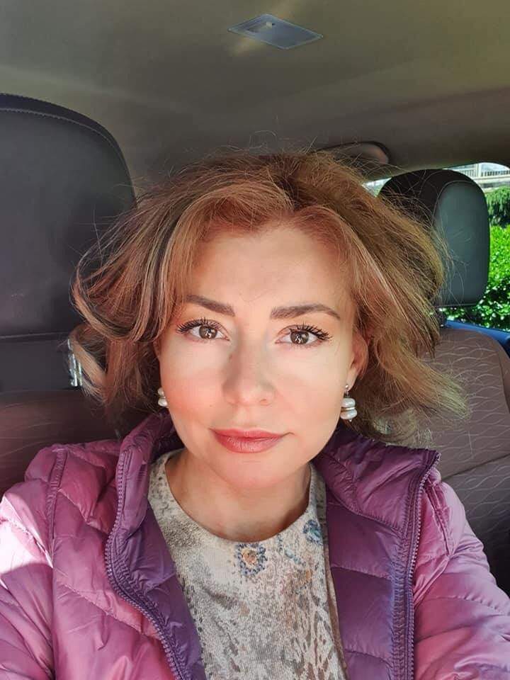 Alexandra Velniciuc într-un selfie. Vedeta poartă o geacă mov și are niște cercei albi la ureche.