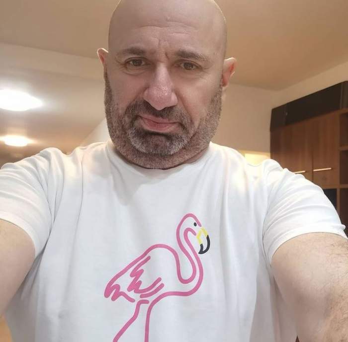 Cătălin Scărlătescu își face un selfie. Chef-ul poartă un tricou alb cu desen cu flamino roz în centru.