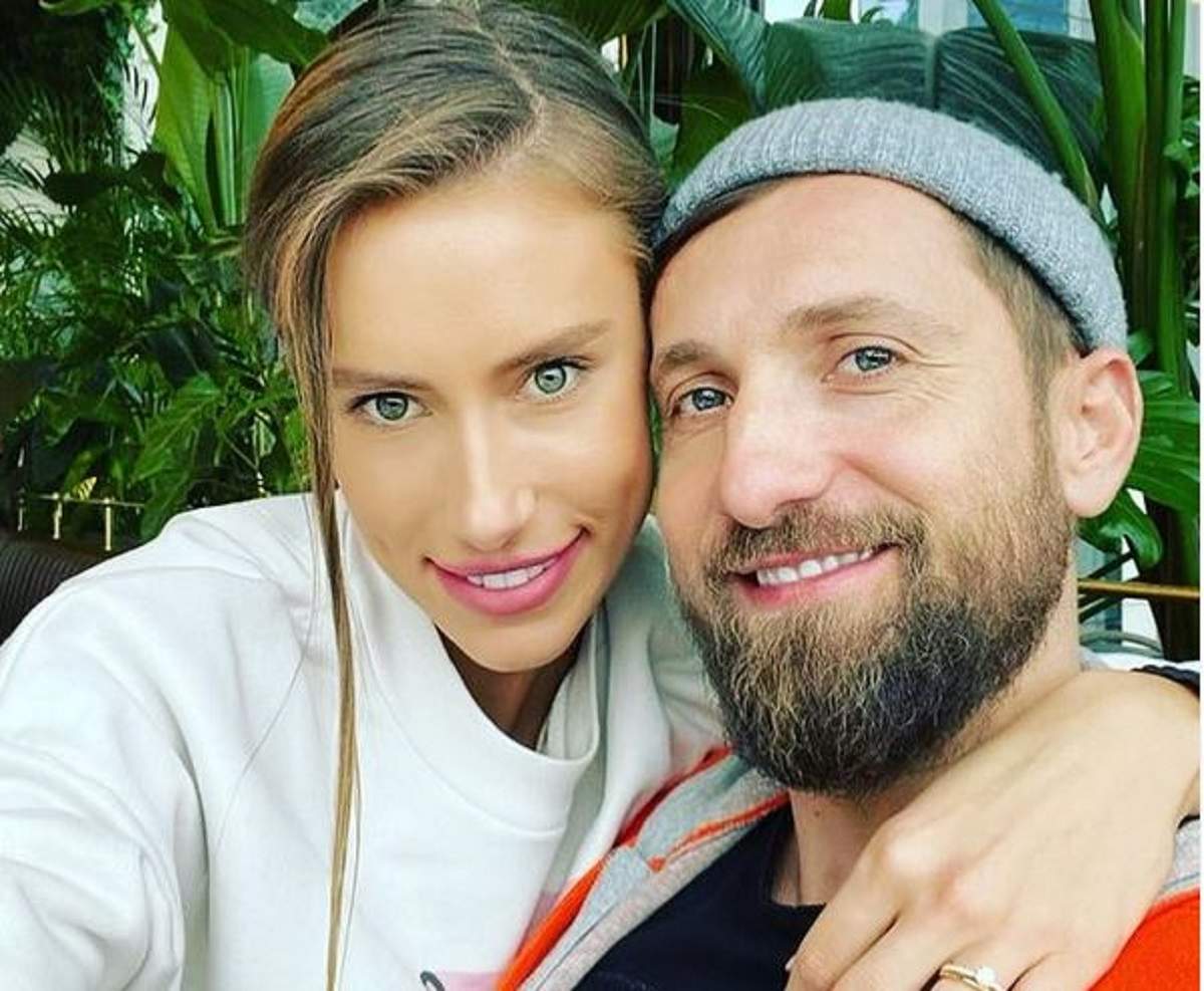 Gabriela Prisăcariu și Dani Oțil într-un selfie. Ea poartă o bluză albă, iar el o căciulă gri. Amândoi zâmbesc.