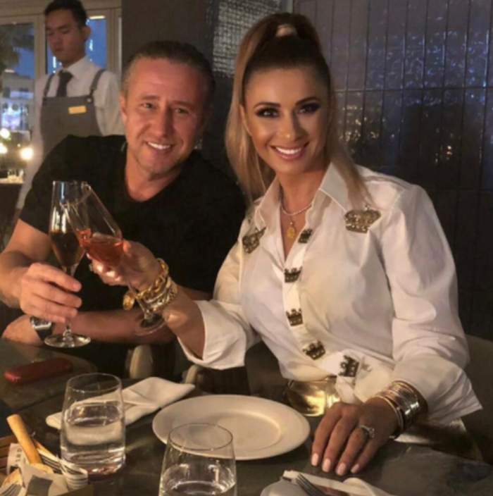 Anamaria Prodan și Laurențiu Reghecampf stau la masa si ciocnesc un pahar de sampanie