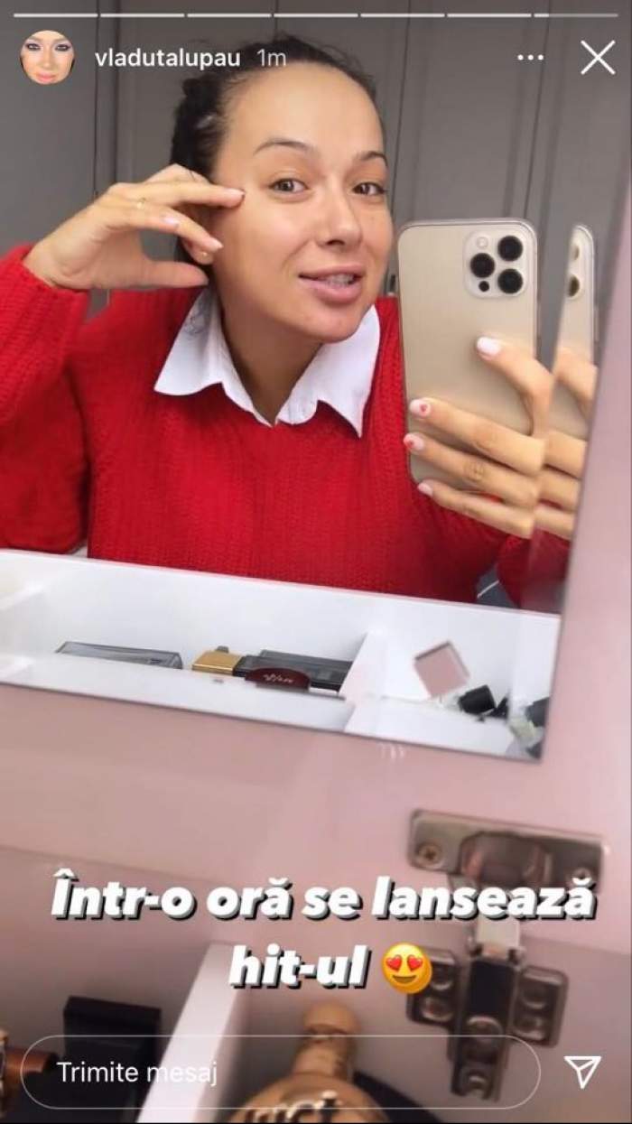 Vlăduța Lupău e nemachiată. Vedeta se filmează în oglindă cu telefonul. Artista poartă o cămașă albă și pulover roșu.