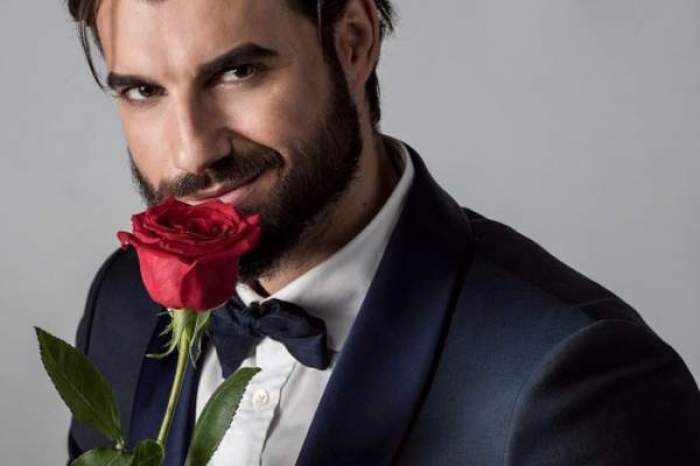 Andi Constantin, în costum negru, cu trandafir roșu în mână