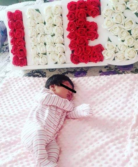 Fiica Alexandrei Diaconescu îmbrăcată în roz, în pat.