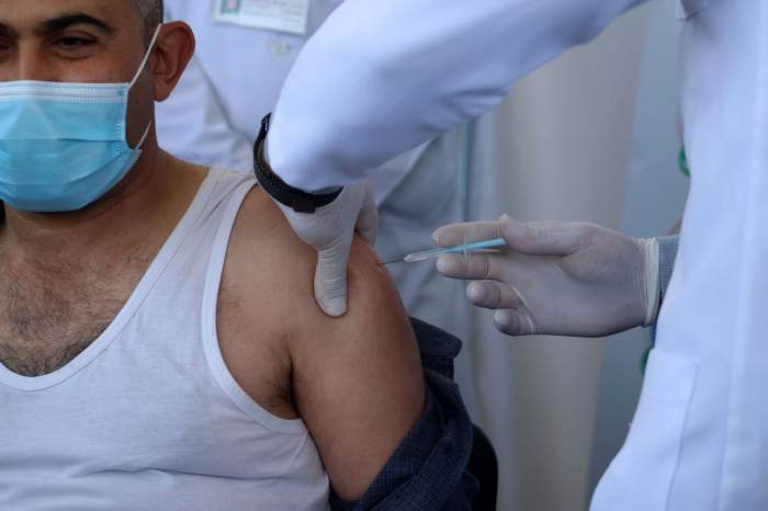 Un bărbat care este vaccinat anti-COVID-19