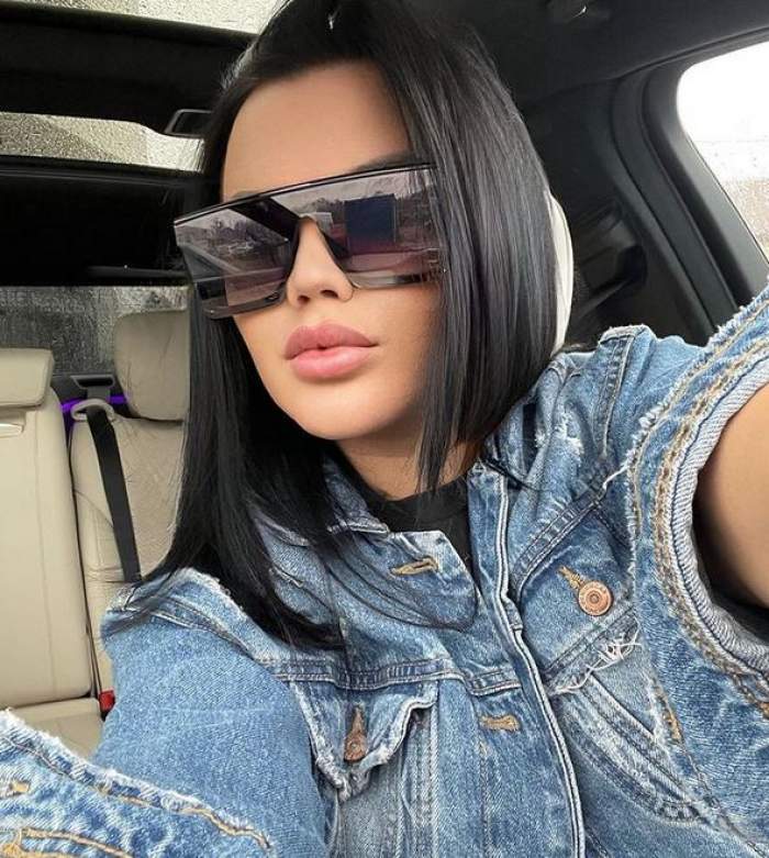 Carmen de la Sălciua se află în mașină. Artista poartă o pereche de ochelari de soare negri și o geacă din denim.