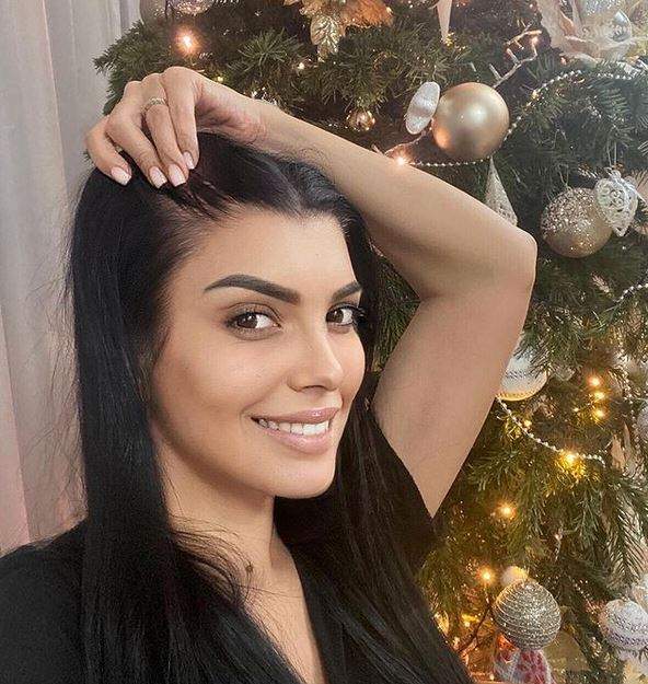 Andreea Tonciu își face un selfie. Vedeta poartă un tricou negru și zâmbește. În spatele ei se vede bradul de Crăciun.