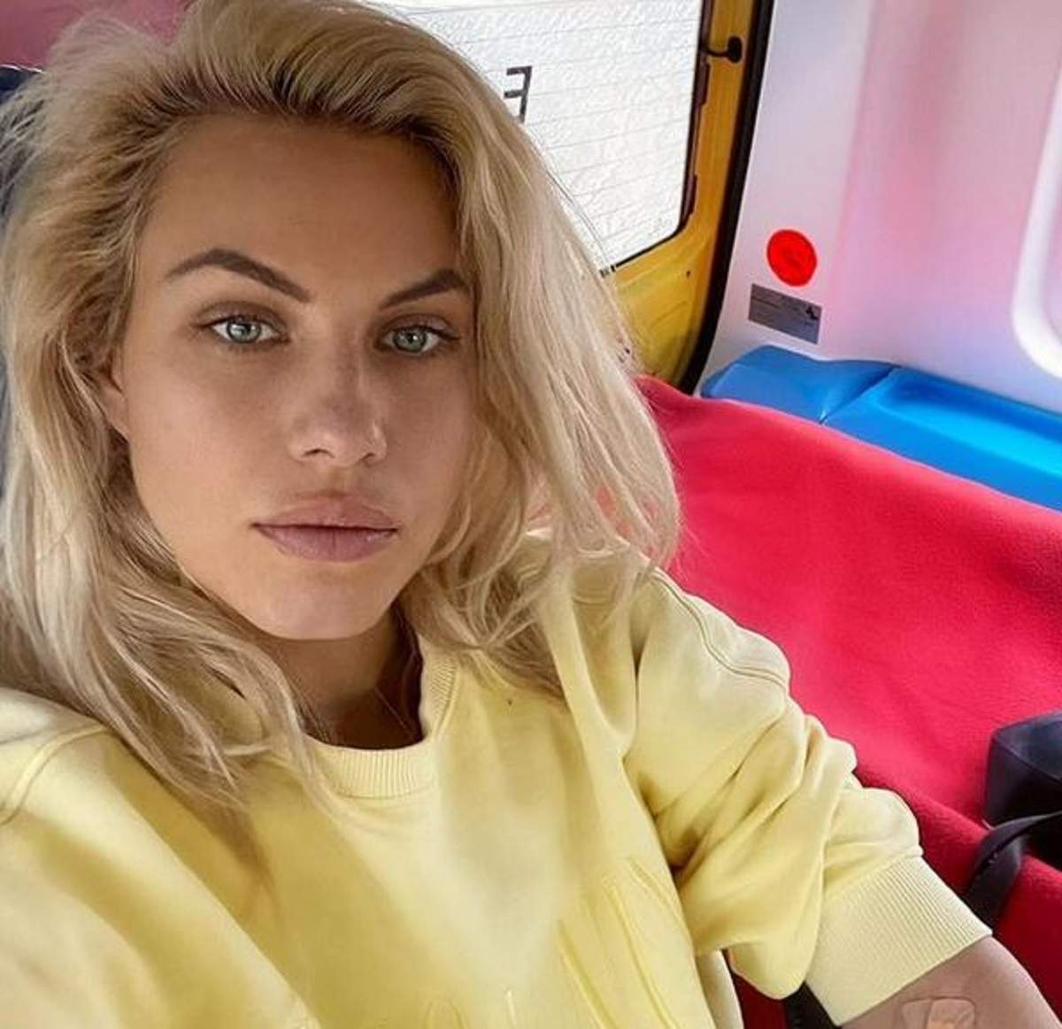 Amna poartă o bluză galbenă și își face un selfie. Artista e în Ambulanță.