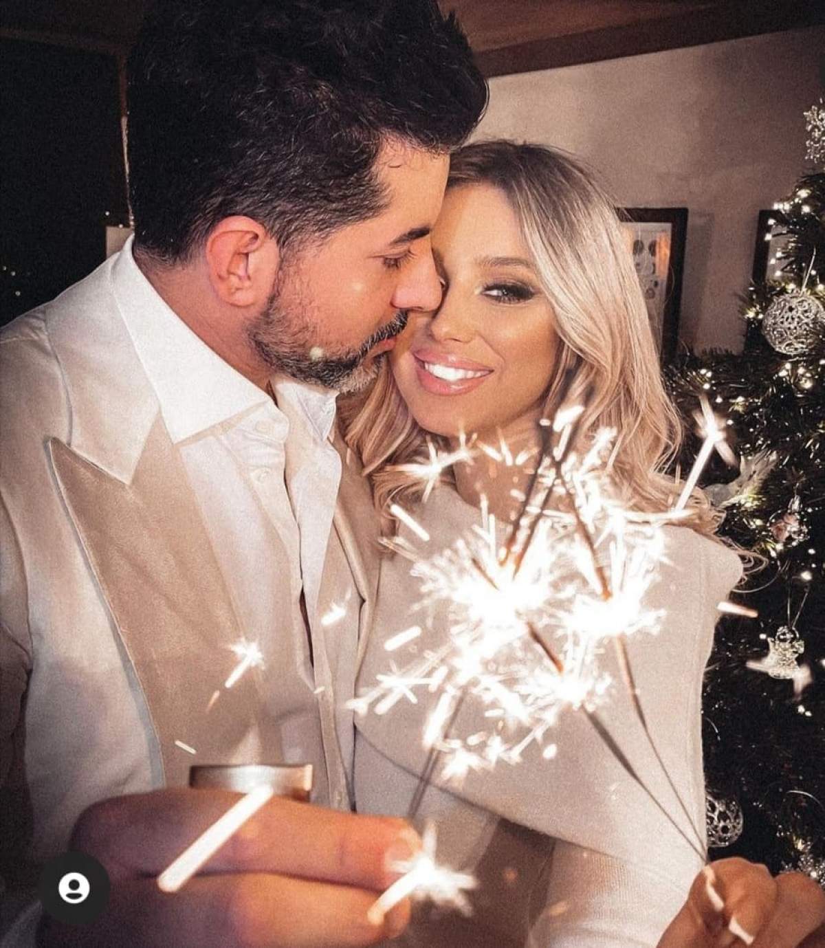 Ela Arjandas și soțul, îmbrăcați în alb, se sărută, cu artificii în mână