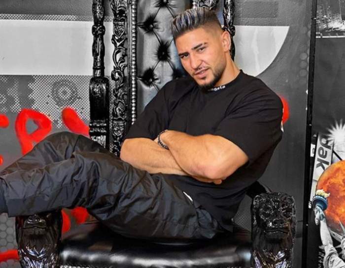 Bogdan Mocanu, pe scaun, îmbrăcat în negru
