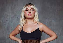 Alexandra Stan, cu mâinile în șolduri, îmbrăcată în negru