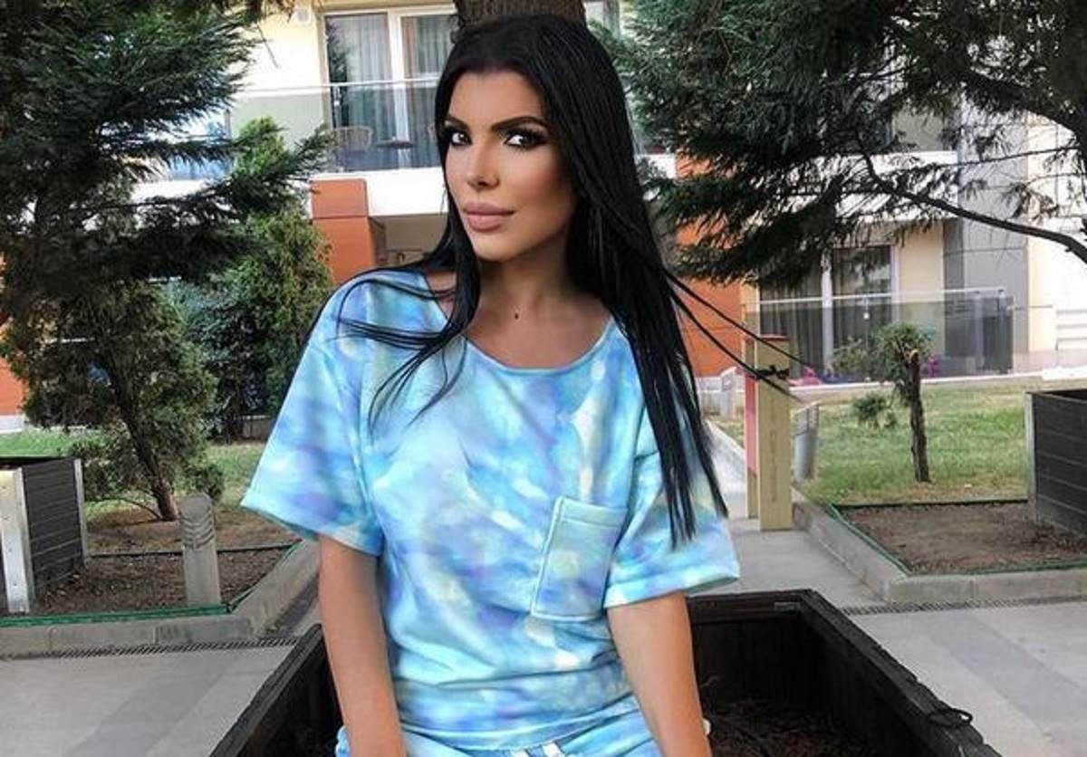 Andreea Tonciu se află în parc. Vedeta stă pe iarbă și e îmbrăcată cu un tricou bleu cu alb și pantaloni din același set.