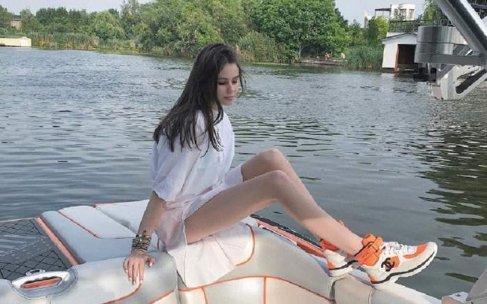 Rebecca Dumitrescu imbracata in alb sta pe marginea apei