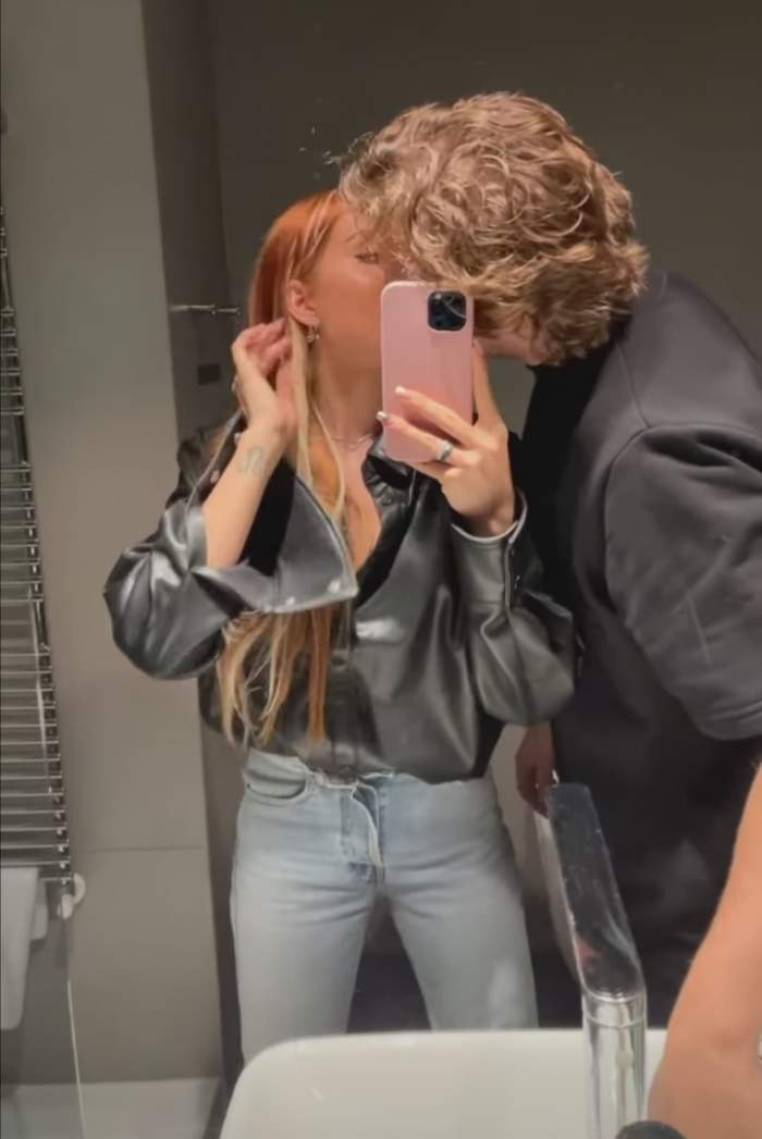 Carmen Grebenișan și ALex Militaru se sărută în fața oglinzii, în timp ce se pozează