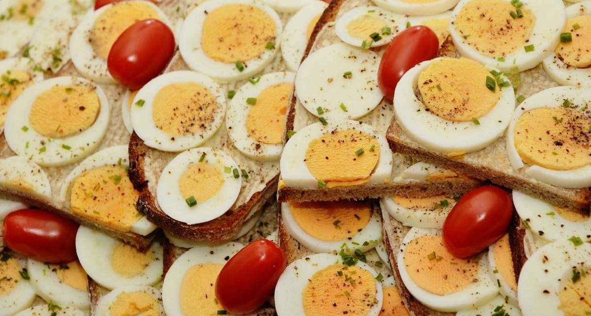Un preparat cu ouă fierte. Acestea sunt servite cu pâine și roșii.