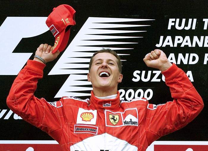 Michael Schumacher, îmbrăcat în roșu, bucurându-se