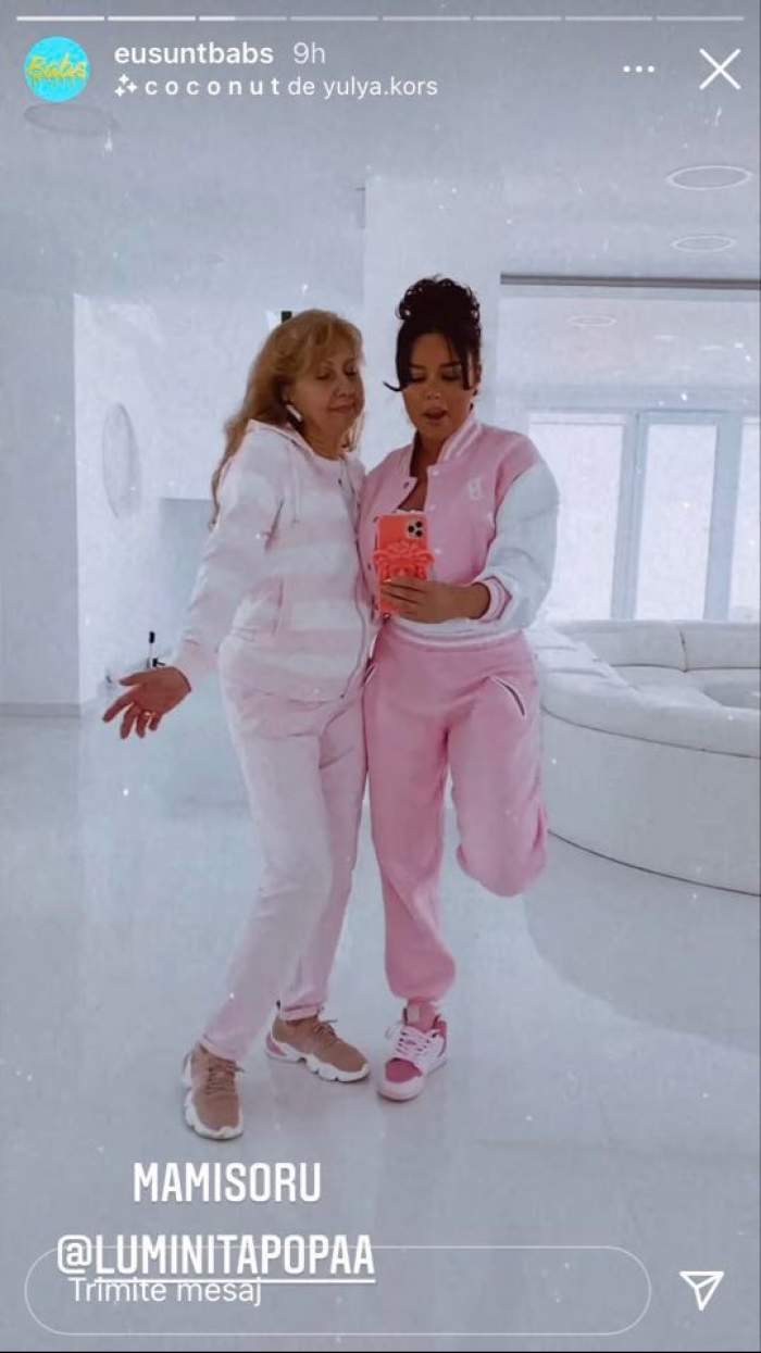 Mama și iubita lui Dorian Popa dansează în fața oglinzii. Amândouă poartă treninguri albe cu roz.