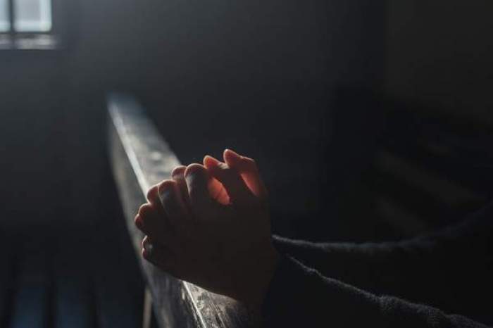 O persoană care se roagă în întuneric