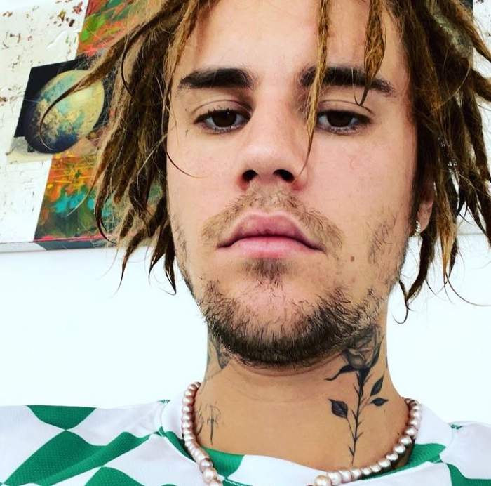 Justin Bieber într-un selfie. Artistul are dreaduri și poartă colorată în pătrate albe și verzi.