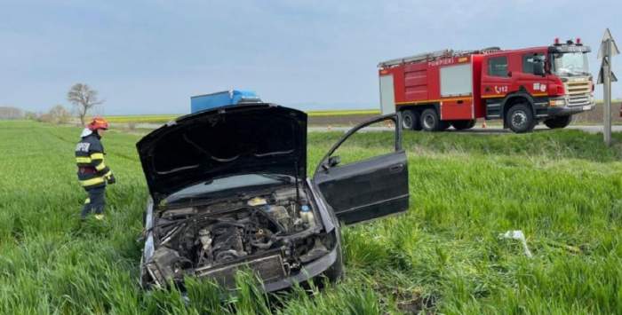 Imagine cu accidentul din județul Prahova, în care un tânăr de 28 de ani a murit. Un pompier e lângă mașina distrusă.