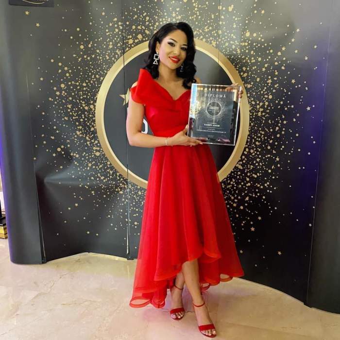 Nasrin în rochie roșie, cu premiul în brațe, la gală.