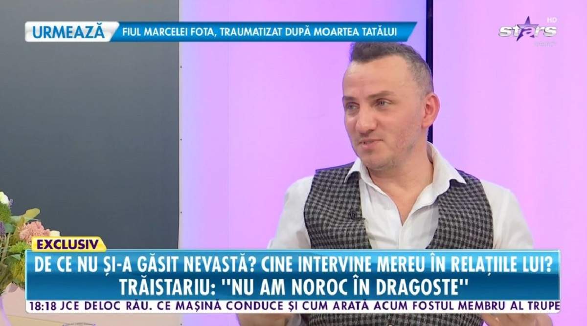 Mihai Trăistariu poartă o cămășă albă și o vestă în pătrățele alb-negru pe deasupra. Artistul dă un interviu pentru Antena Stars.