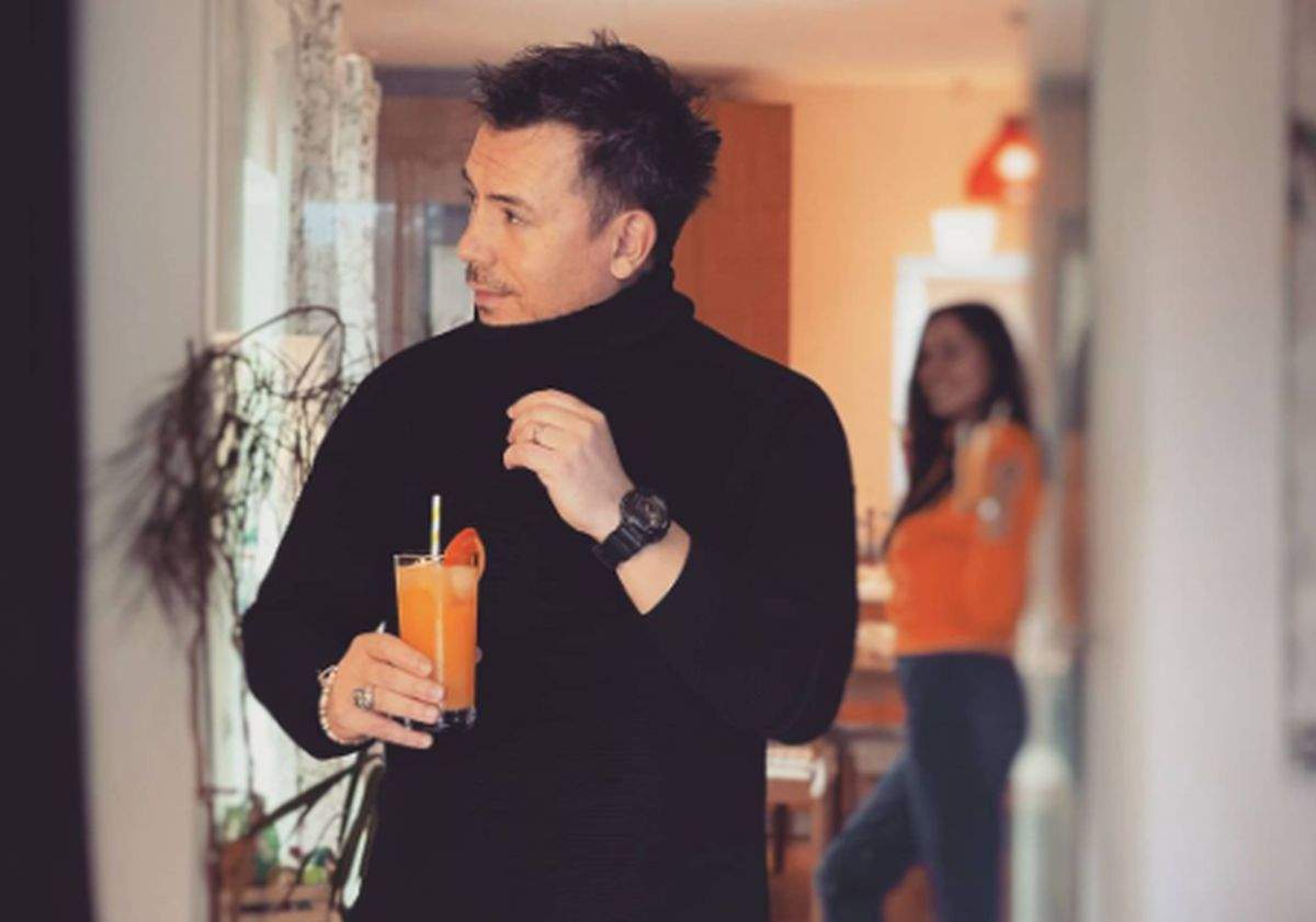 Răzvan Fodor imbracat in negru cu un pahar de suc in mana