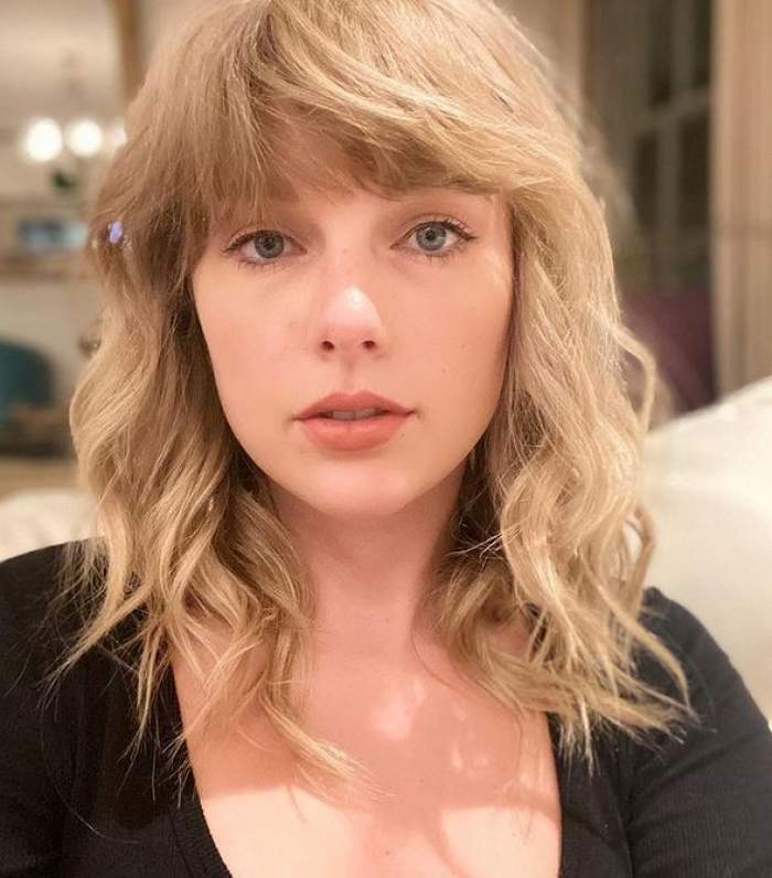 Taylor Swift își face un selfie. Vedeta poartă o bluză neagră.