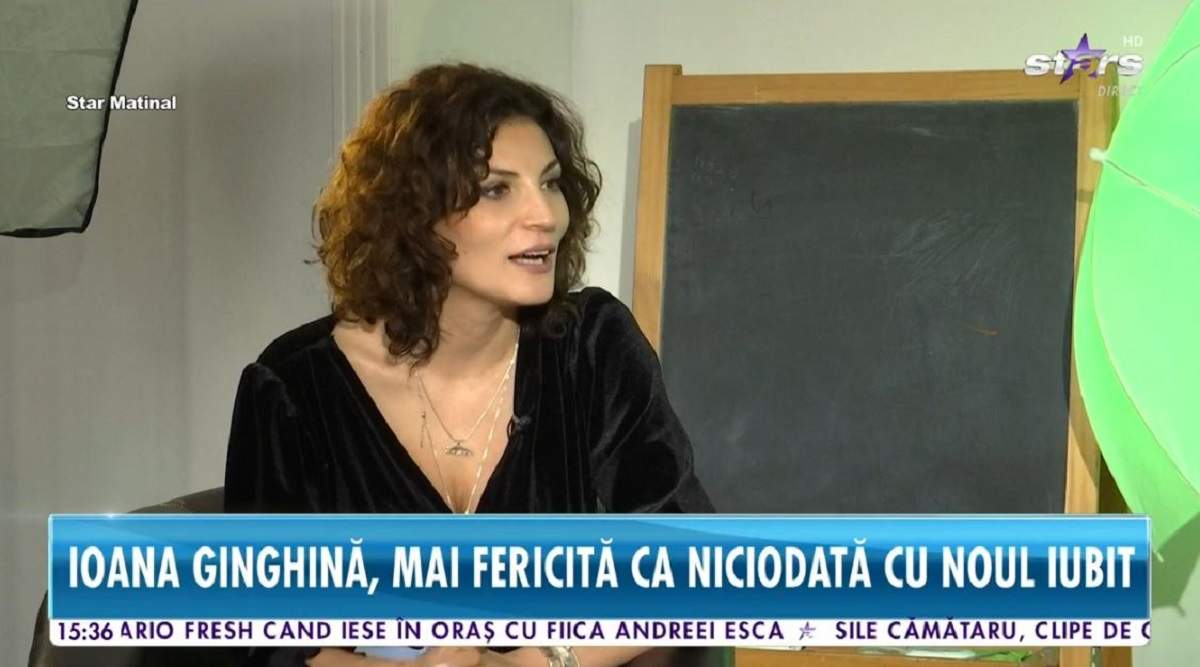Ioana Ginghină dă un interviu la Antena Stars. Vedeta poartă o bluză neagră și are gura deschisă.