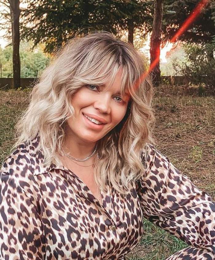 Gina Pistol e îmbrăcată într-o cămașă cu animal print, stil leopard. Vedeta zâmbește larg.