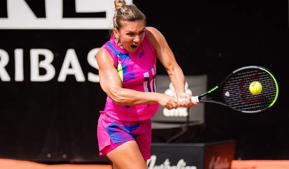 Simona Halep e la un meci de tenis. Sportiva poartă un echipament roz, format din maiou și pantaloni scurți.